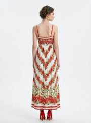 Back view of a woman in a floral print maxi dress with spaghetti straps, standing against a white background.