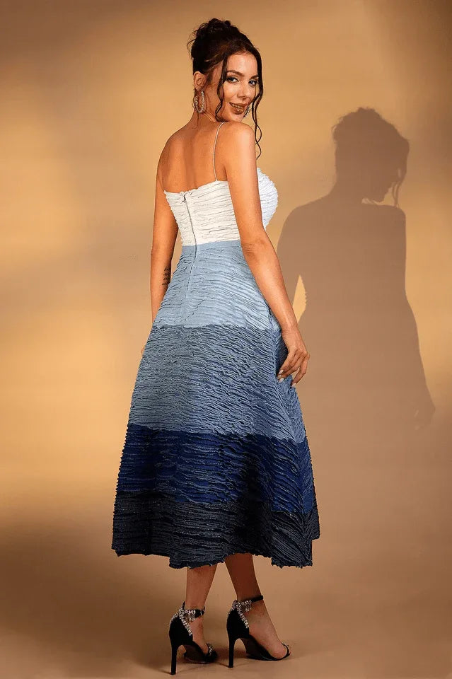Back view of a woman in a white and blue ombre textured midi dress