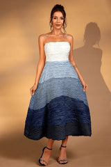 Woman wearing a white and blue ombre textured midi dress with spaghetti straps