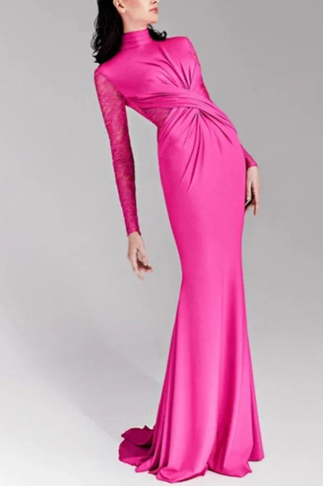 Woman wearing a long hot pink satin gown with lace sleeves and ruched detailing.