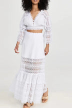 Side view of a woman in a white lace two-piece set, showcasing the flow of the maxi skirt.