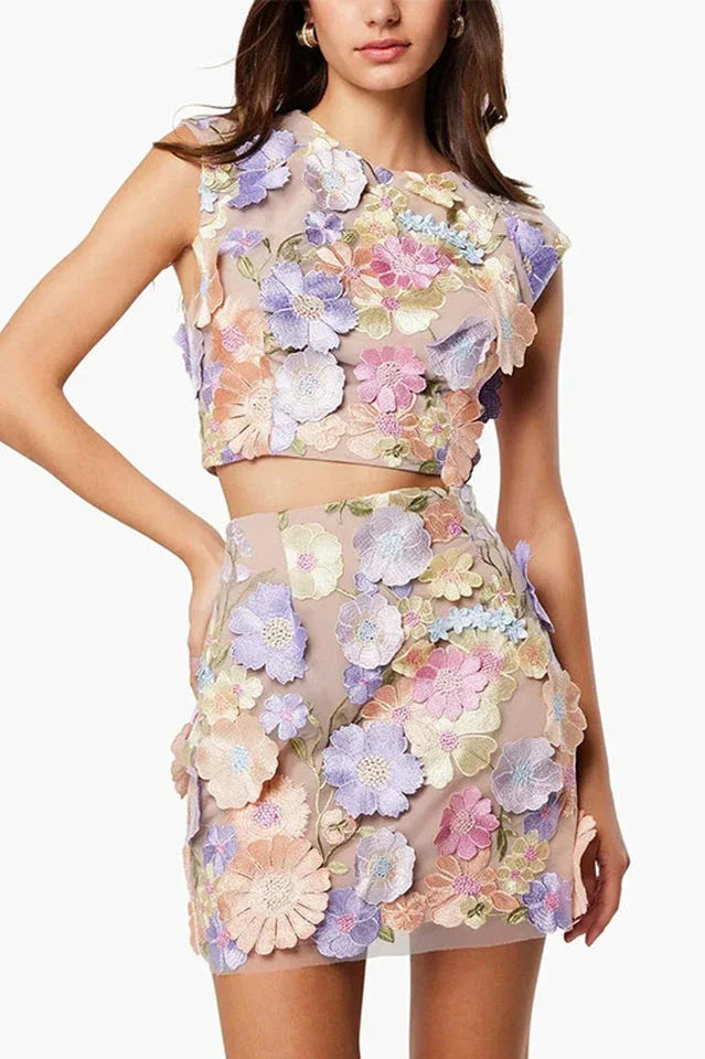 Close-up of a woman wearing a floral applique crop top and mini skirt, showing detailed embroidery. Main image