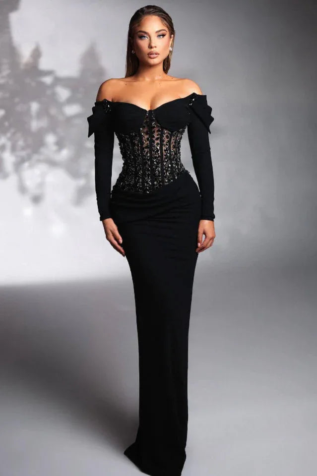 woman wearing a long black off-the-shoulder velvet dress with a sparkling corset bodice Main image