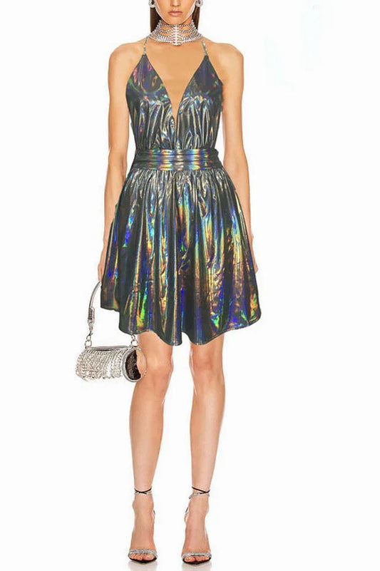 Woman wearing a short holographic halter dress with a deep V-neck and A-line skirt, accessorized with a sparkly clutch and heels.