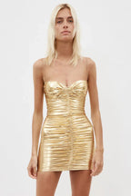 Woman wearing a gold metallic ruched mini dress with a sweetheart neckline and thin straps, front view.