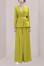 Woman wearing a lime green pantsuit with wide-leg pants and a lapel blazer.