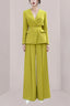 Woman wearing a lime green pantsuit with wide-leg pants and a lapel blazer.