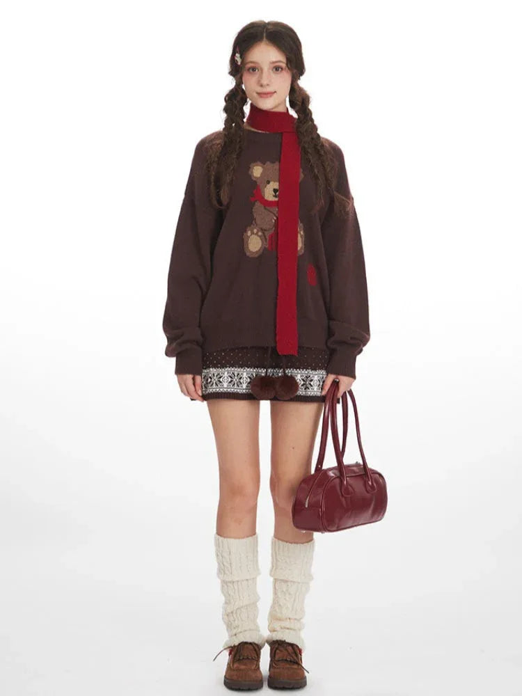 Woman wearing a brown knit sweater with a teddy bear graphic and a red scarf, paired with a patterned skirt and leg warmers Main image