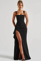 Woman in a black sleeveless floor-length gown with a high slit and square neckline