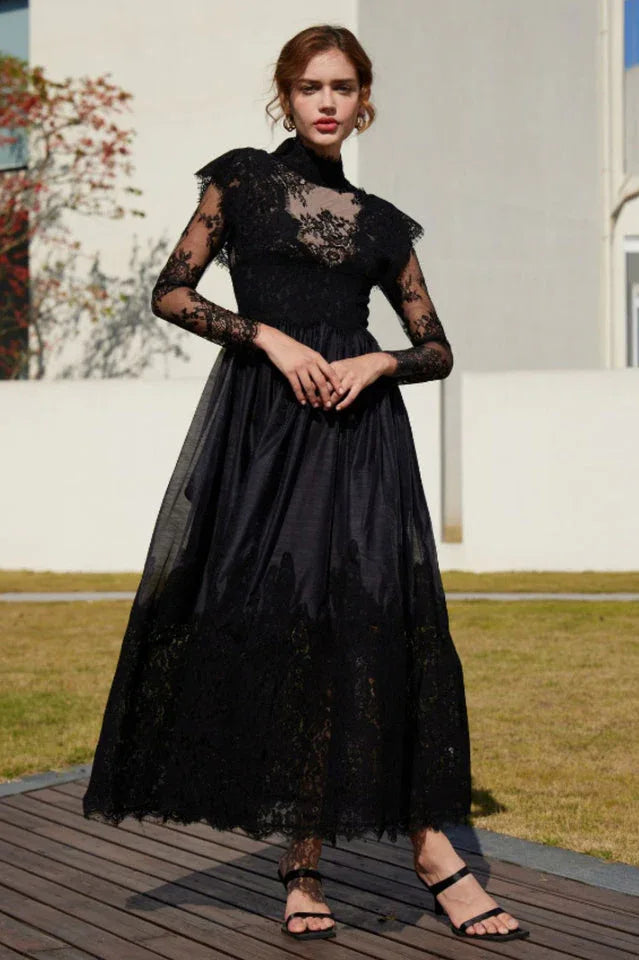 Full-length view of a woman in a black lace and satin formal gown.