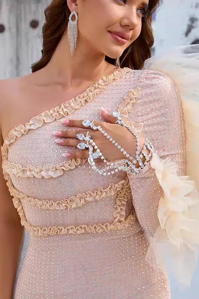 Detail of the hand jewelry and embellishments on a shimmering dress.