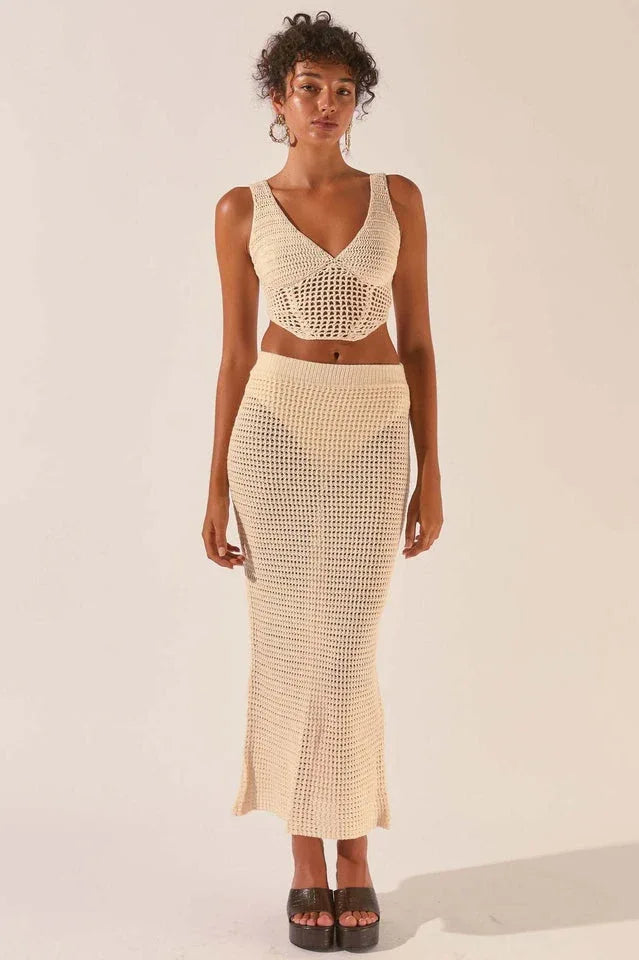 Woman wearing a cream crochet knit crop top and matching maxi skirt, front view. Main image