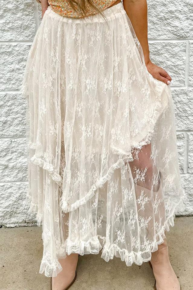 A woman wearing a white lace tiered ruffle skirt with tan boots.