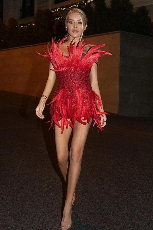 Woman walking in a red sequined mini dress with feather trim