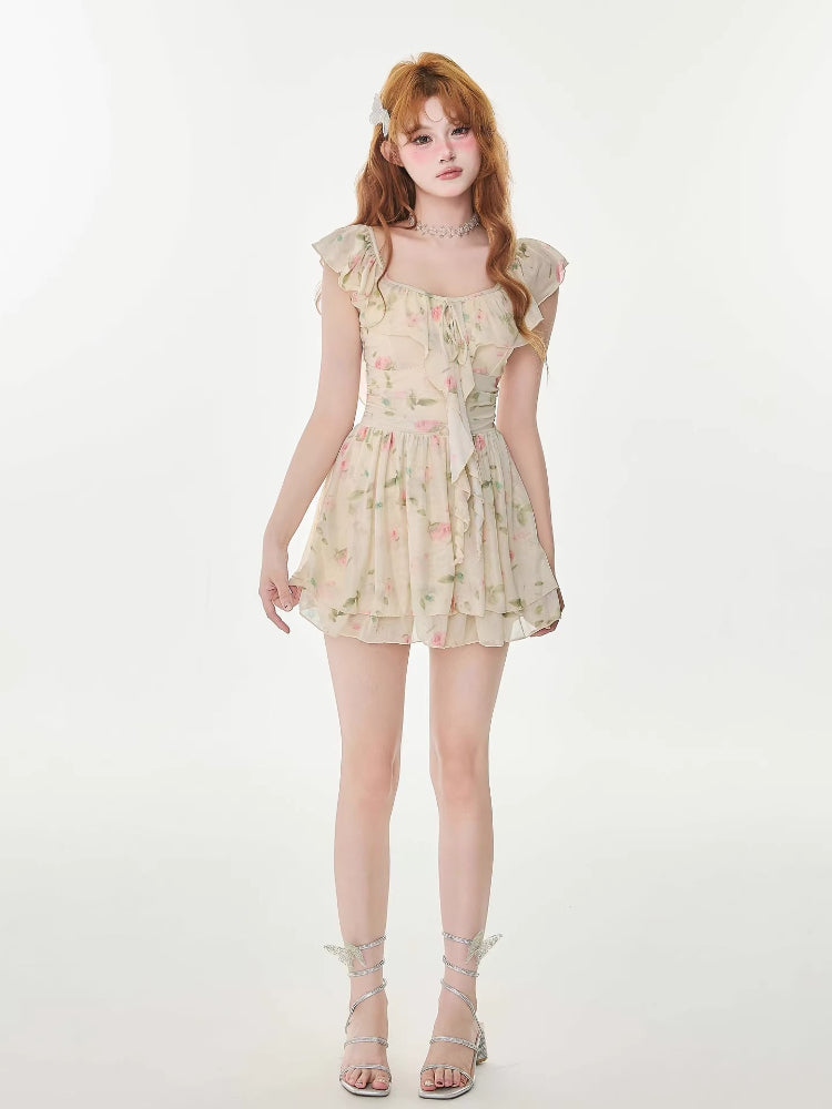 Full-length shot of a woman in a floral print a-line mini dress with tiered skirt and silver strappy heels.