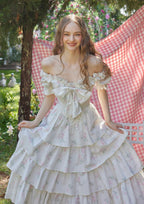 Back view of a white floral print off-the-shoulder tiered dress with puffed sleeves and a lace-up detail