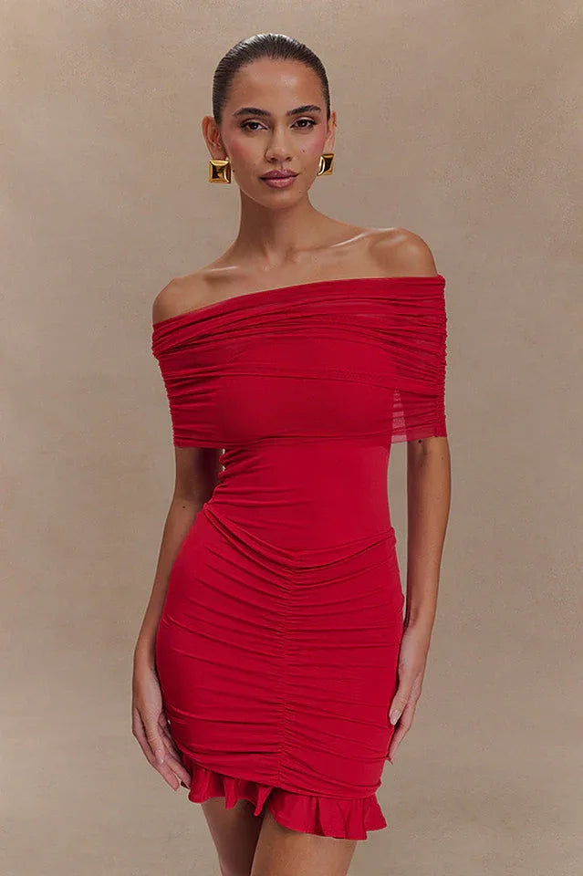 Model wearing a red off-the-shoulder ruched dress with a sheer overlay and ruffled hem. Main image