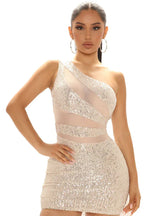 Close-up of a woman wearing a champagne sequined one-shoulder mini dress with sheer mesh paneling.