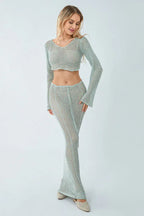 Woman wearing a light blue crochet knit crop top and maxi skirt set, front view.