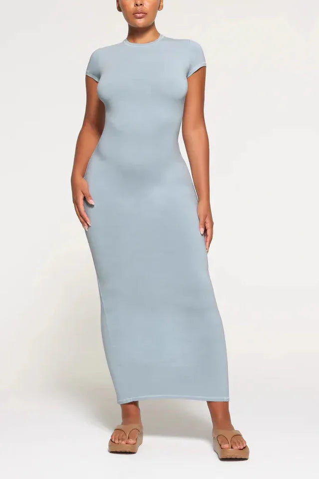 Woman wearing a light blue, full-length, fitted knit dress with cap sleeves and a round neckline.