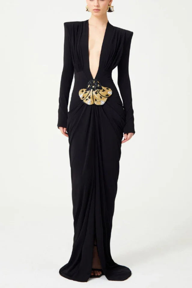 Black long-sleeved gown with a plunging V-neckline and a draped skirt, featuring a jeweled butterfly embellishment at the waist.