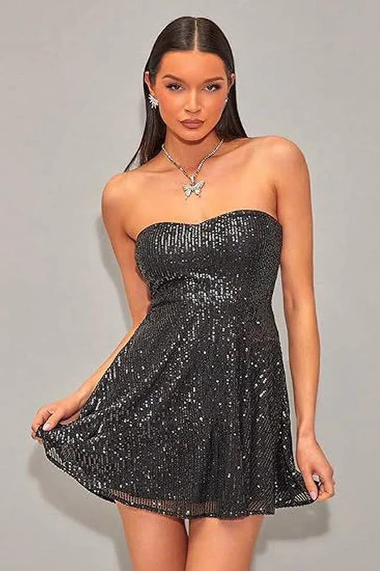 Woman wearing a black sequined strapless dress with a sweetheart neckline and A-line skirt, front view
