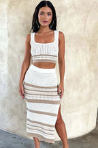 Woman wearing a white and tan striped knit cropped tank top and matching midi skirt with a side slit, slightly angled front view