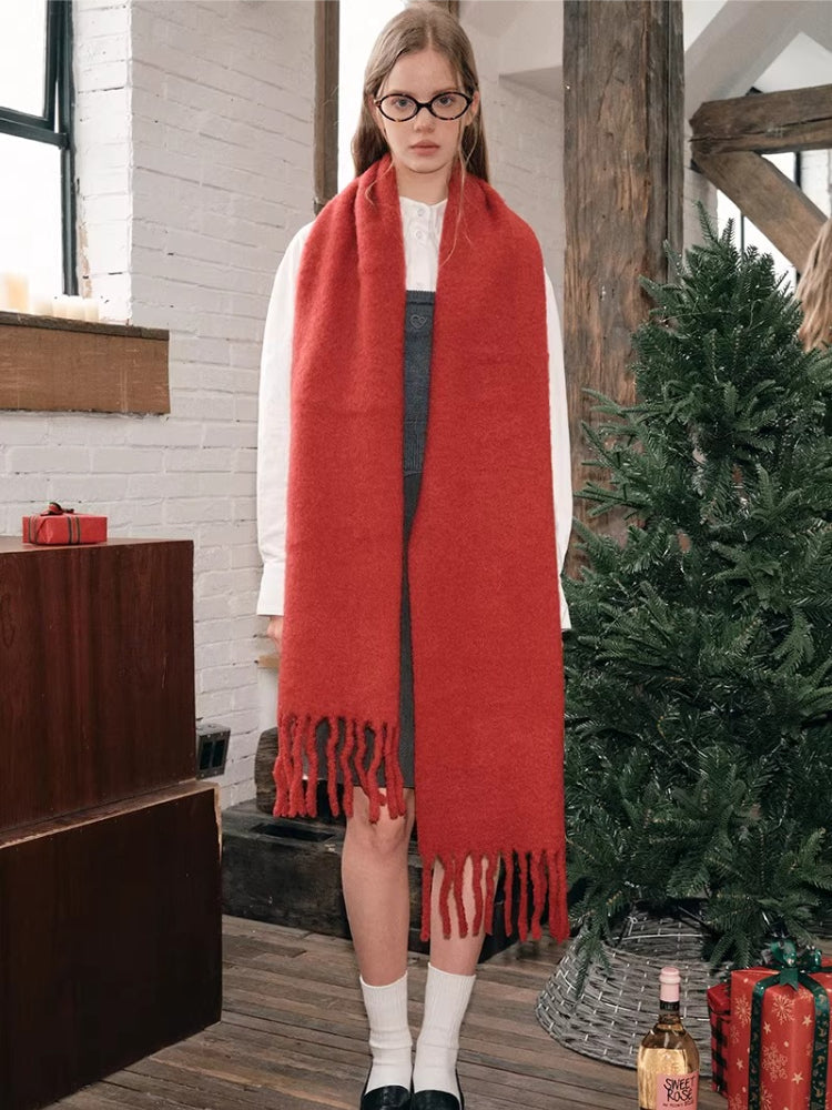 Full body shot of a woman wearing a red oversized scarf with fringed ends