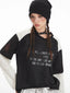Close-up of the graphic print on the layered shirt, showing the text and star details.