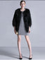 Woman wearing a black faux fur cropped jacket over a grey knit dress, holding a gold clutch.