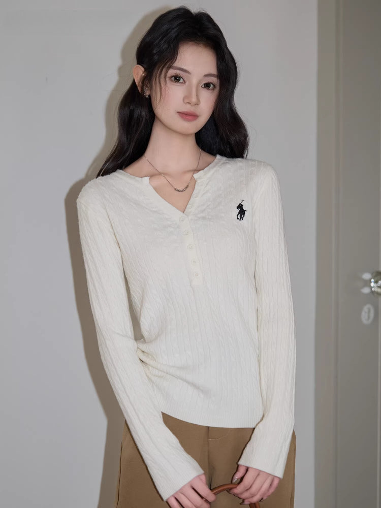 Full-body shot of a woman standing, showcasing the white cable knit henley sweater and brown wide-leg pants.