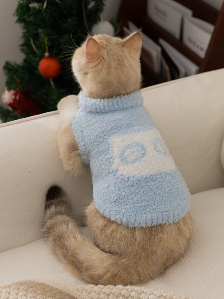 The back of a light blue fuzzy cat sweater worn by a cream-colored cat. The cat is looking away from the camera.