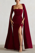 Full-length view of a woman in a maroon gown with a sweetheart neckline, draped waist, and flowing cape sleeves.