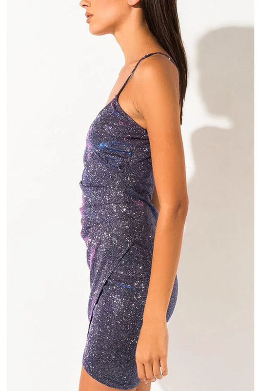 Side view of a woman in a sparkly purple mini dress.