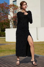 Full body shot of a woman in a black embellished maxi dress with a thigh-high slit.