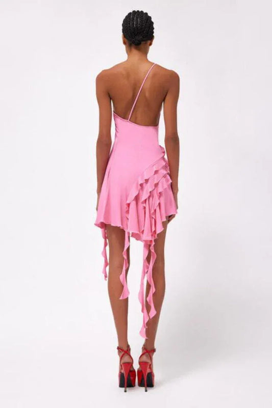 back view of a woman wearing a pink one-shoulder mini dress with ruffled asymmetrical hemline