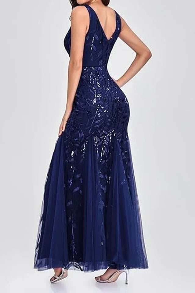 Woman wearing a floor-length navy blue sequined mermaid gown from the back, highlighting the V-neckline and mermaid train.