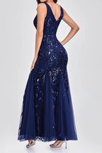 Woman wearing a floor-length navy blue sequined mermaid gown from the back, highlighting the V-neckline and mermaid train.