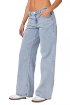 Side view of light wash wide leg jeans worn by a woman