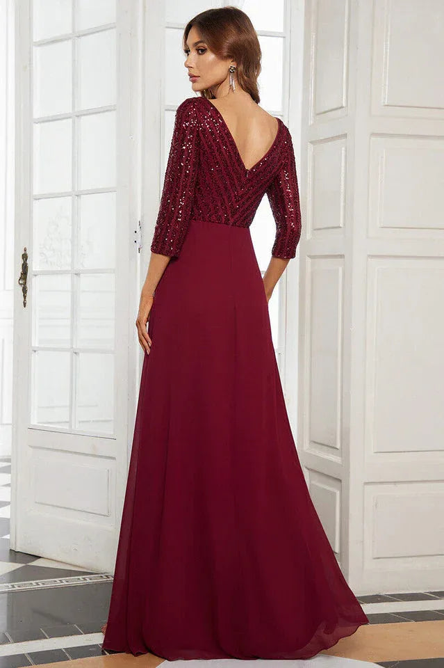 Back view of a woman in a floor-length burgundy sequined formal gown with 3/4 sleeves.