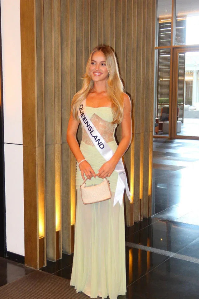Woman wearing a light green strapless gown and a 'Queensland' sash