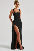 Front view of a woman wearing a black ruched gown with a thigh-high slit