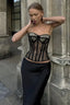 Woman wearing a black lace corset top and a black skirt outdoors