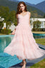 Full length shot of a woman in a light pink tiered tulle dress with a v-neckline, standing by a pool.