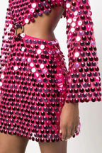 Close-up of the cut-out detail and ring embellishment on the pink sequined two-piece set.
