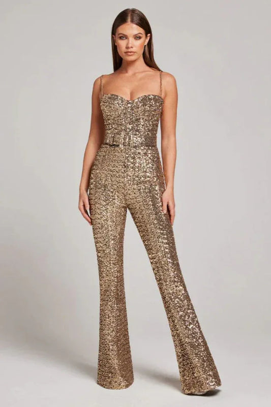 Woman wearing a gold sequined jumpsuit with a sweetheart neckline and wide legs, standing with hands at her hips.