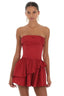 Woman wearing a red strapless mini dress with a tiered ruffled skirt and lace-up back detail, shown from the front.