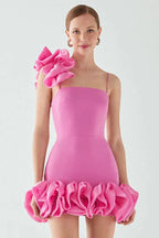 model wearing a bright pink mini dress with a large ruffle on one shoulder and a ruffled hem