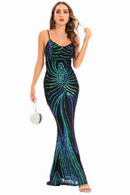 Woman wearing a black floor-length sequined gown with a geometric pattern in green and blue, featuring spaghetti straps and a sweetheart neckline.