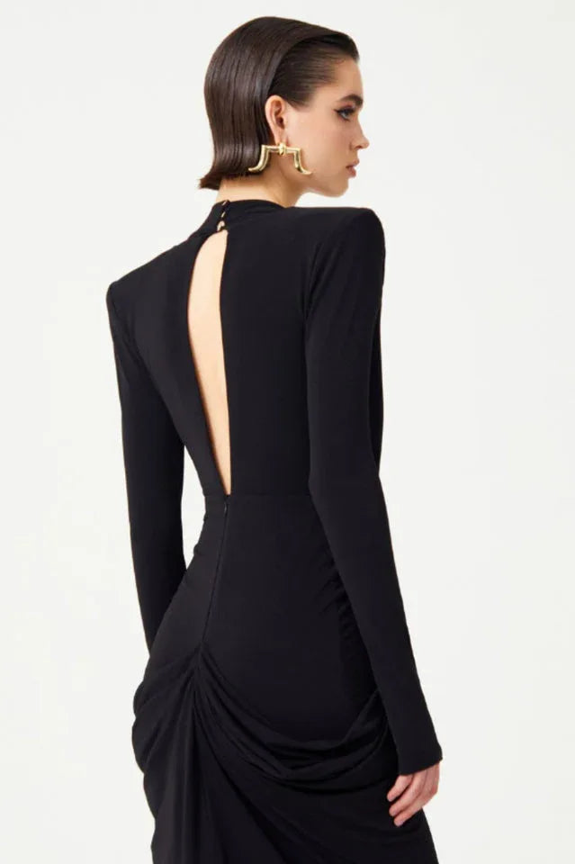 Back view of the black gown, highlighting the open back detail and draped skirt.